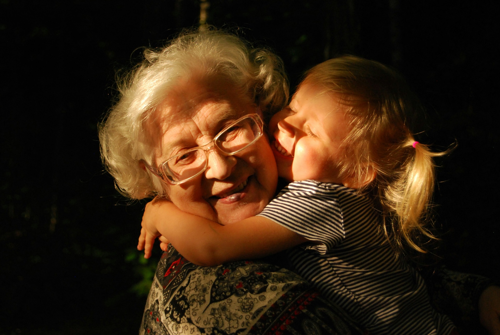 Grandmother hugging granddaughter in warm light