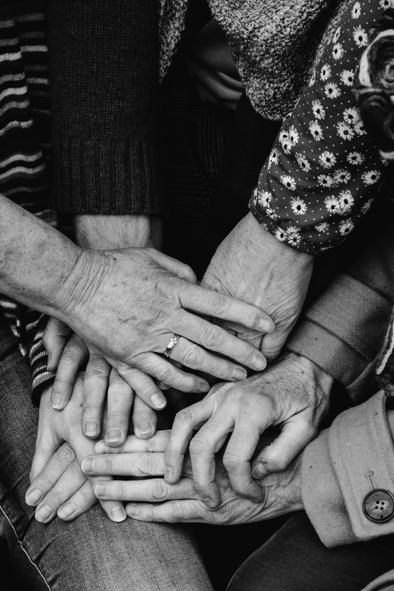 Stack of hands across generations, black and white