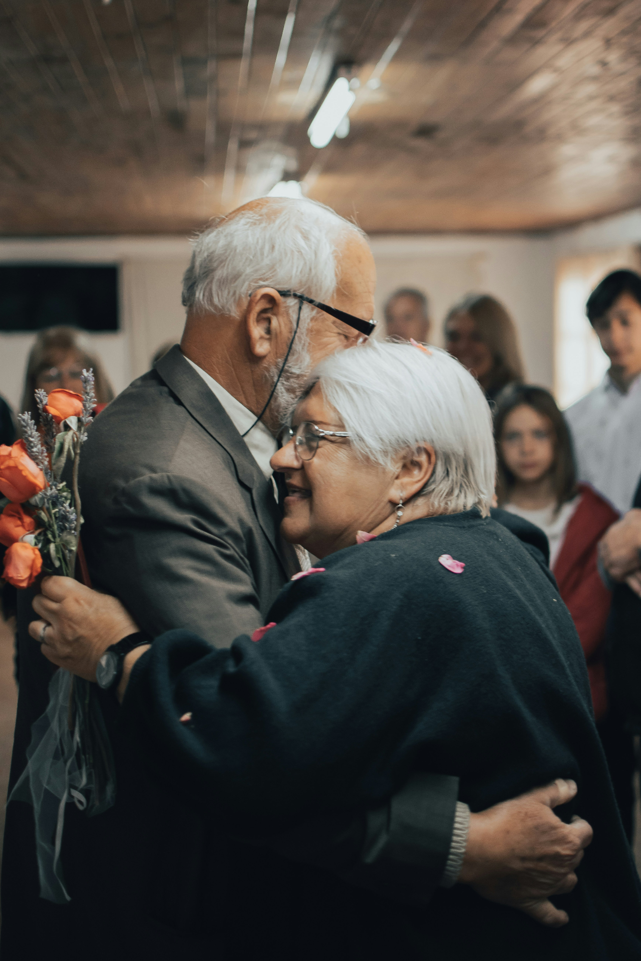 Older couple embracing at a celebration with witnesses
