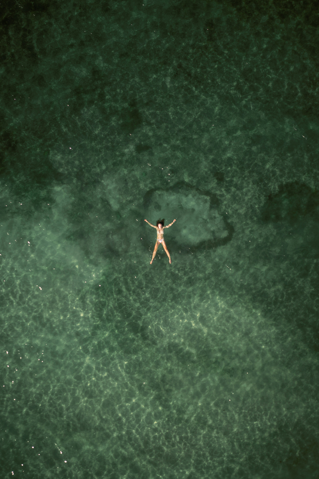 A single swimmer in turquoise water